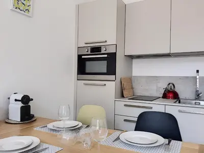 a kitchen with a table with two chairs and an oven at Nestor&Jeeves - CAESARS - Hyper center - Shopping avenue in Nice