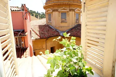 a view of a building from a window with a plant at Ze Perfect Place - Vieux Nice - Exceptionnel Appartement - Calme et Terrasse avec vues in Nice
