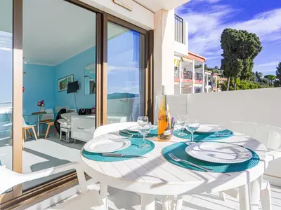 a row of blue lounge chairs in front of a building at Apartment L'Ange Gardien-2 by Interhome in Beaulieu-sur-Mer