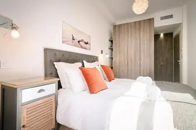 a bedroom with a large white bed with orange pillows at 