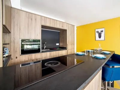 a kitchen with a black counter and a yellow wall at Residence Blue Harmony in Nice