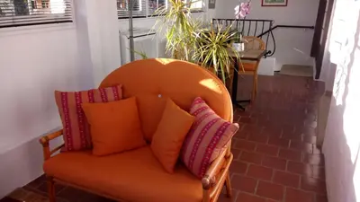 an orange chair with pillows sitting in a room at Chambres d'hôtes Les Terrasses du Soleil in Cagnes-sur-Mer