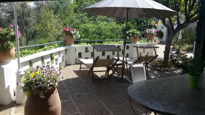 a patio with tables and chairs and an umbrella at Chambres d'hôtes Les Terrasses du Soleil in Cagnes-sur-Mer