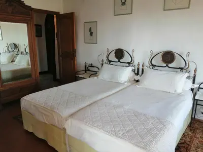 a bedroom with a bed with white sheets and a mirror at Chambres d'hôtes Les Terrasses du Soleil in Cagnes-sur-Mer
