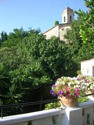 a flower pot on a railing with a building in the background at Chambres d'hôtes Les Terrasses du Soleil in Cagnes-sur-Mer