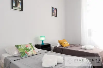 a room with two beds and a night stand at Suite Gioia five stars holiday house in Nice