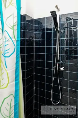 a black tiled shower in a bathroom with a blow dryer at Suite Gioia five stars holiday house in Nice