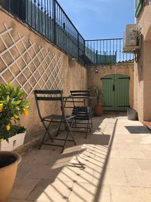 two chairs sitting next to a wall with a green door at appartement en rez de villa in Gattières