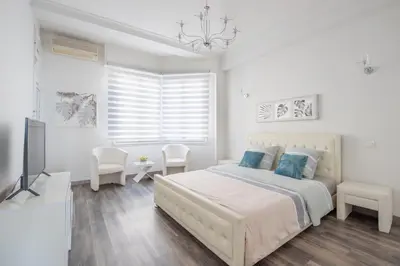 a white bedroom with a bed and a television at SEA FRONT SUITE - Panoramic View with Terrace - 85 m in Nice