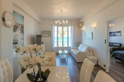 a living room with a couch and a table with flowers at SEA FRONT SUITE - Panoramic View with Terrace - 85 m in Nice