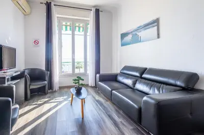 a living room with a black leather couch and a table at SEA FRONT SUITE - Panoramic View with Terrace - 85 m in Nice