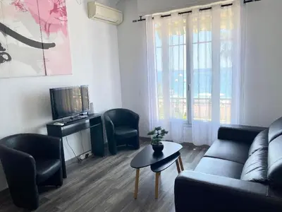 a living room with a couch and chairs and a tv at SEA FRONT SUITE - Panoramic View with Terrace - 85 m in Nice