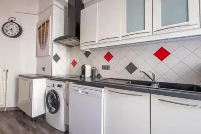 a kitchen with white cabinets and a washer and dryer at SEA FRONT SUITE - Panoramic View with Terrace - 85 m in Nice