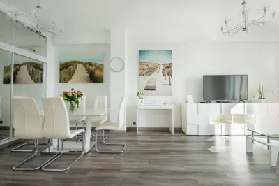 a white dining room with a table and a tv at SEA FRONT SUITE - Panoramic View with Terrace - 85 m in Nice