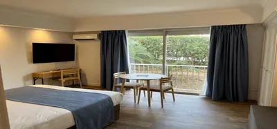 a hotel room with a bed and a table and a window at Résidence Carlton - Rénovée avec Piscine in Beaulieu-sur-Mer