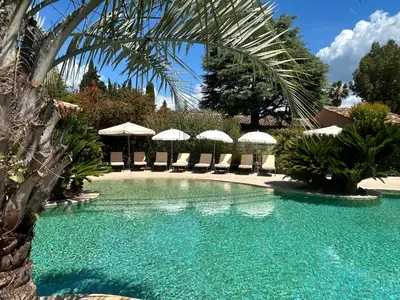 a swimming pool with chairs and umbrellas at Domaine De Respelido in Carros