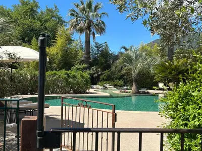 a pool with a table and an umbrella and palm trees at Domaine De Respelido in Carros