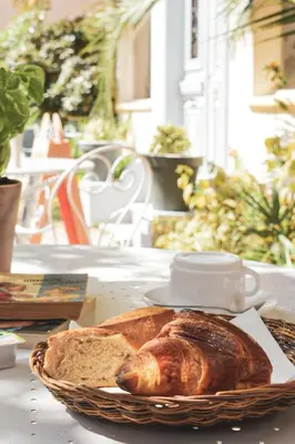 a basket of bread and a plate of bread at Hôtel Belle Meunière in Nice