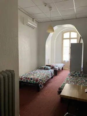 a room with three beds and a window at Hôtel Belle Meunière in Nice