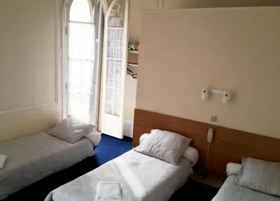 a room with two beds and a window at Hôtel Belle Meunière in Nice
