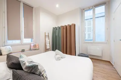 a bedroom with a bed and two windows at Charming 1 Bdr Old town in Nice