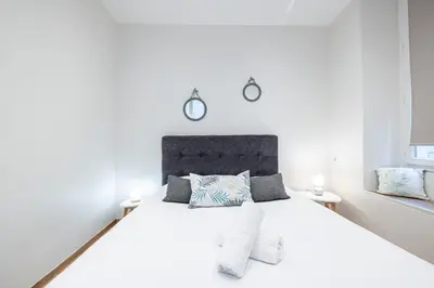 a bedroom with a white bed with two clocks on the wall at Charming 1 Bdr Old town in Nice