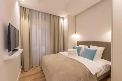 a bedroom with a bed with blue pillows and a television at COURS SALEYA Renovated 3 Bedrooms 1 min to Beach Air Conditioning in Nice