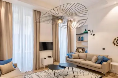 a living room with a couch and a chandelier at COURS SALEYA Renovated 3 Bedrooms 1 min to Beach Air Conditioning in Nice