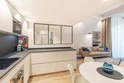a kitchen with a table and a living room at COURS SALEYA Renovated 3 Bedrooms 1 min to Beach Air Conditioning in Nice