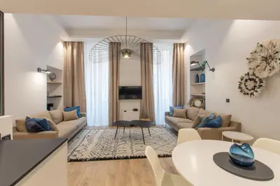 a living room with a couch and a table at COURS SALEYA Renovated 3 Bedrooms 1 min to Beach Air Conditioning in Nice