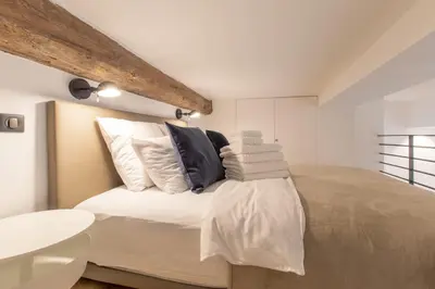 a bedroom with a large bed with white sheets and pillows at COURS SALEYA Renovated 3 Bedrooms 1 min to Beach Air Conditioning in Nice