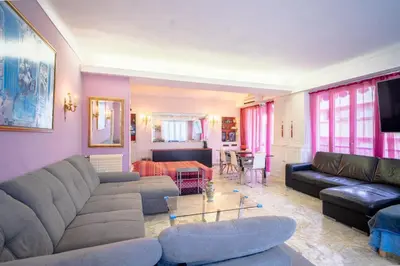a living room with a couch and a table at Big apart 140m2 5min walk to beach sea &Promenade 3 double rooms,big living room 42m2, 3 showers,9 beds, free parking in Nice