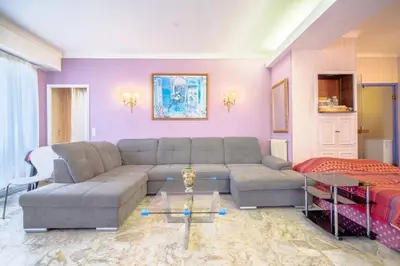 a living room with a couch and a table at Big apart 140m2 5min walk to beach sea &Promenade 3 double rooms,big living room 42m2, 3 showers,9 beds, free parking in Nice