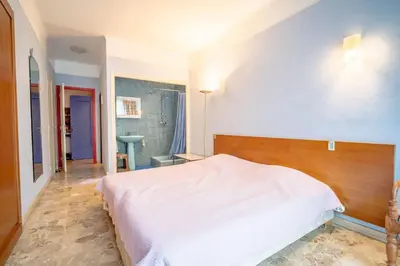a bedroom with a white bed and a blue wall at Big apart 140m2 5min walk to beach sea &Promenade 3 double rooms,big living room 42m2, 3 showers,9 beds, free parking in Nice