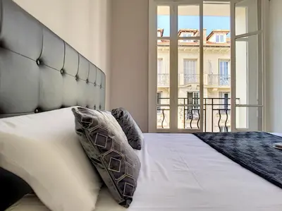 a bedroom with a large bed with a large window at Nestor&Jeeves - LILAS BUFFA - Central - Close sea - Top Floor in Nice