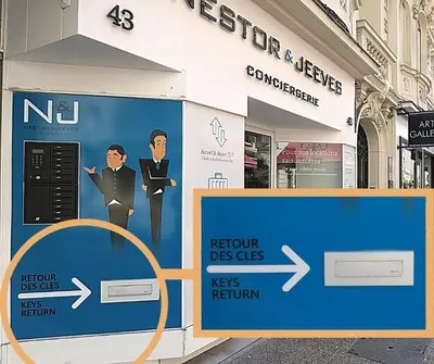 a sign in front of a store with a picture of two men at Le Catinat in Nice