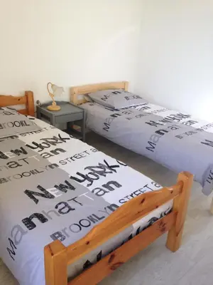 two beds sitting next to each other in a bedroom at Le 43 in La Trinité