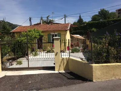 a gate to a house with a fence at Le 43 in La Trinité