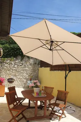 a table and chairs with a large umbrella at Le 43 in La Trinité