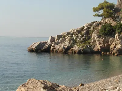 a beach on the side of a rocky cliff at Le 43 in La Trinité