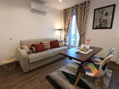 a living room with a couch and a table at Chouette Massena in Nice