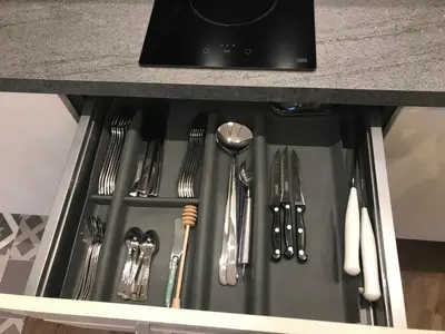 a drawer with silver utensils in a kitchen counter at Chouette Massena in Nice