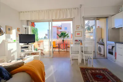 a living room with a couch and a table with chairs at Le lutin in Saint-Laurent-du-Var