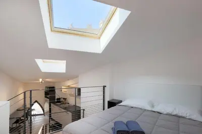 a white bedroom with a bed and a window at Patio Wilson in Nice