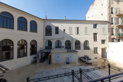 a large white building with a car parked in front at Patio Wilson in Nice