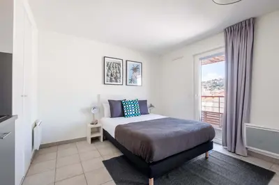 a bedroom with a bed and a large window at Student Factory Nice in Nice