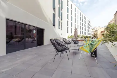a patio with chairs and tables on a building at Student Factory Nice in Nice
