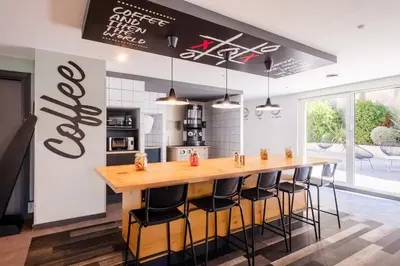 a kitchen with a large wooden bar with stools at Student Factory Nice in Nice