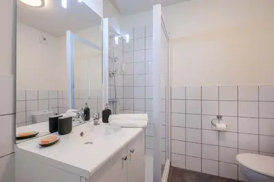 a white bathroom with a sink and a mirror at Student Factory Nice in Nice