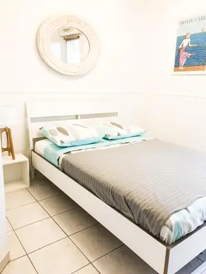a white bedroom with a bed and a mirror at Portobello residence in Nice